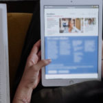 Woman reading content SEO on handheld device