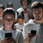 Lots of people staring at mobile phones