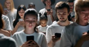 Lots of people staring at mobile phones