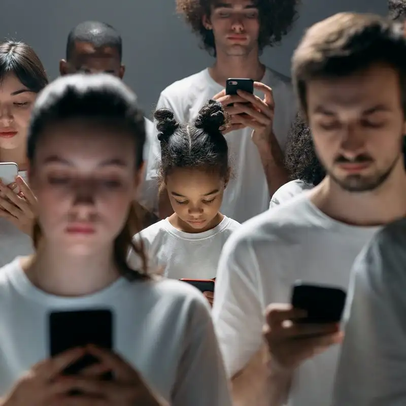 Lots of people staring at mobile phones